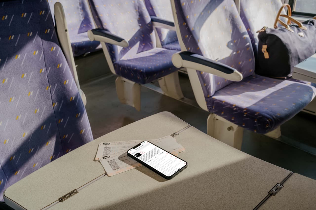 mockuuups-iphone-13-mockup-on-table-in-train Large